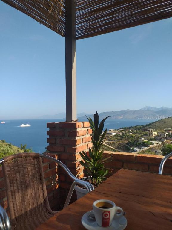 a cup of coffee on a table with a view of the ocean at Grand Seaview Apartments in Ksamil