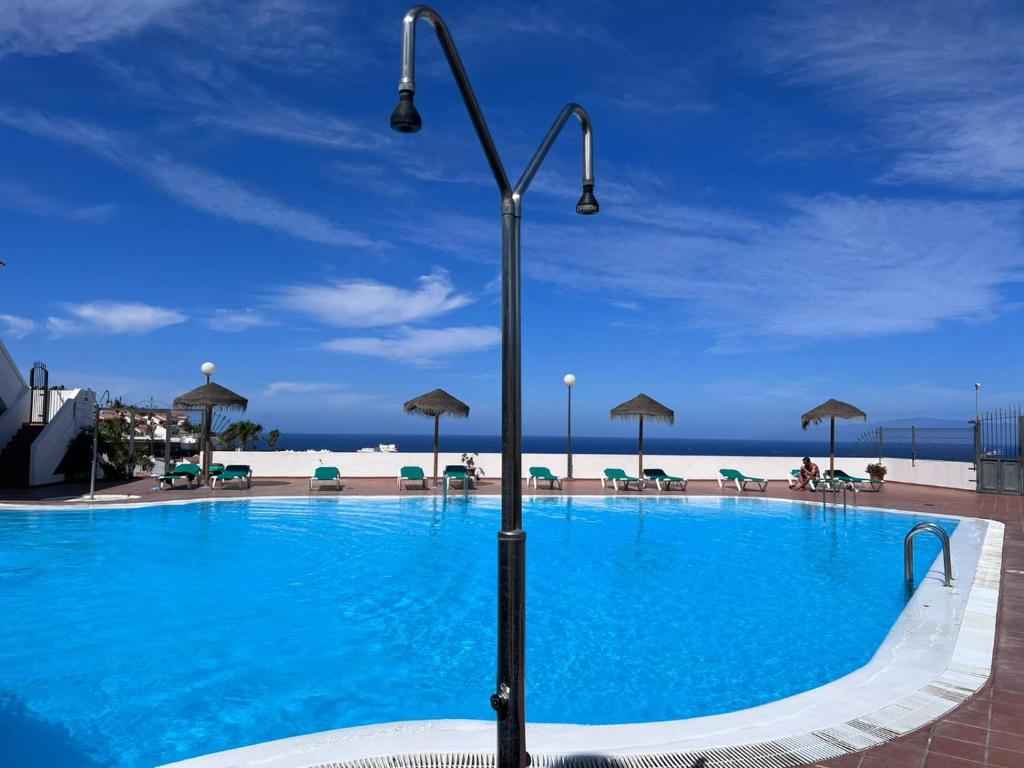 una gran piscina azul con un poste de luz al lado en New Deluxe Sunny Bungalow en Adeje