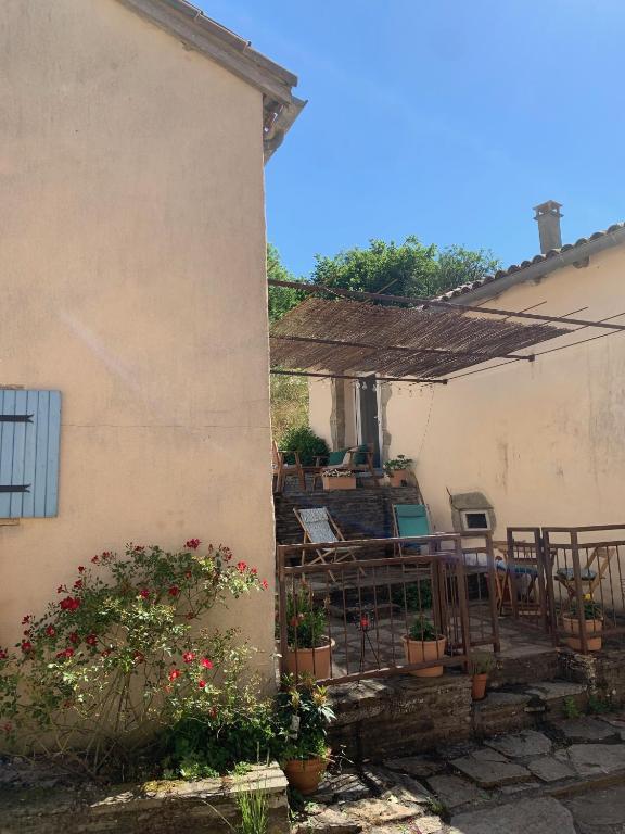 une maison avec une terrasse agrémentée de plantes en pot dans l'établissement le hameau de Sylvanes, à Sylvanès