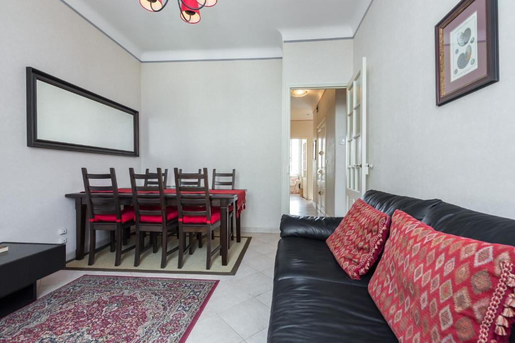 a living room with a couch and a table with chairs at Three bedroom two bathroom apartment in center of Cannes on quiet street minutes from the Palais - 2002 in Cannes