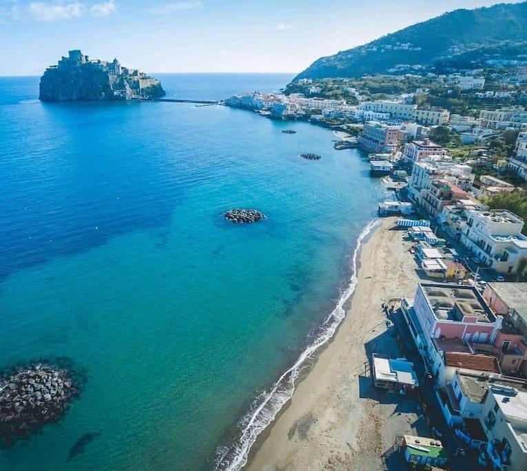 una vista aerea di una spiaggia con edifici e l'oceano di Beach House Ischia a Ischia