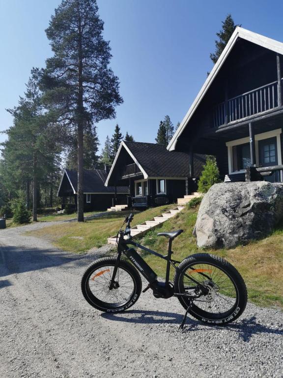 a bike parked on a gravel road in front of a house at Aava Sky Village in Aavasaksa