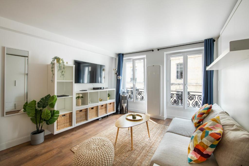 ein Wohnzimmer mit einem Sofa und einem Tisch in der Unterkunft SUPER CENTRAL - Sentier Studio - Air Conditioning in Paris