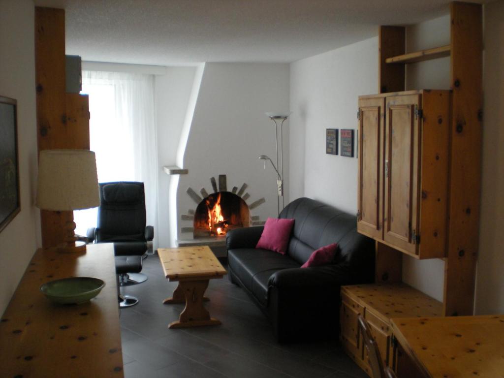ein Wohnzimmer mit einem Sofa und einem Kamin in der Unterkunft Parsennresidenz in Davos