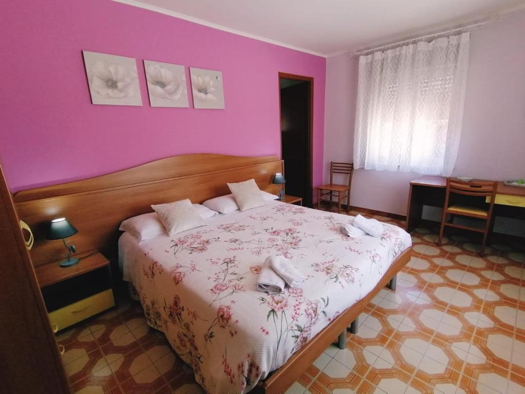 una camera da letto con un letto con un animale bianco sopra di Albergo Mendolia a Milazzo