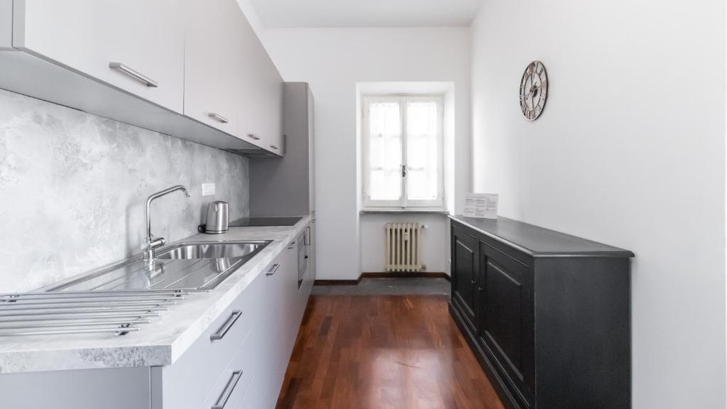 kuchnia z białymi szafkami, zlewem i oknem w obiekcie Italianway - Barberini Elegantia Apartments Roma w Rzymie
