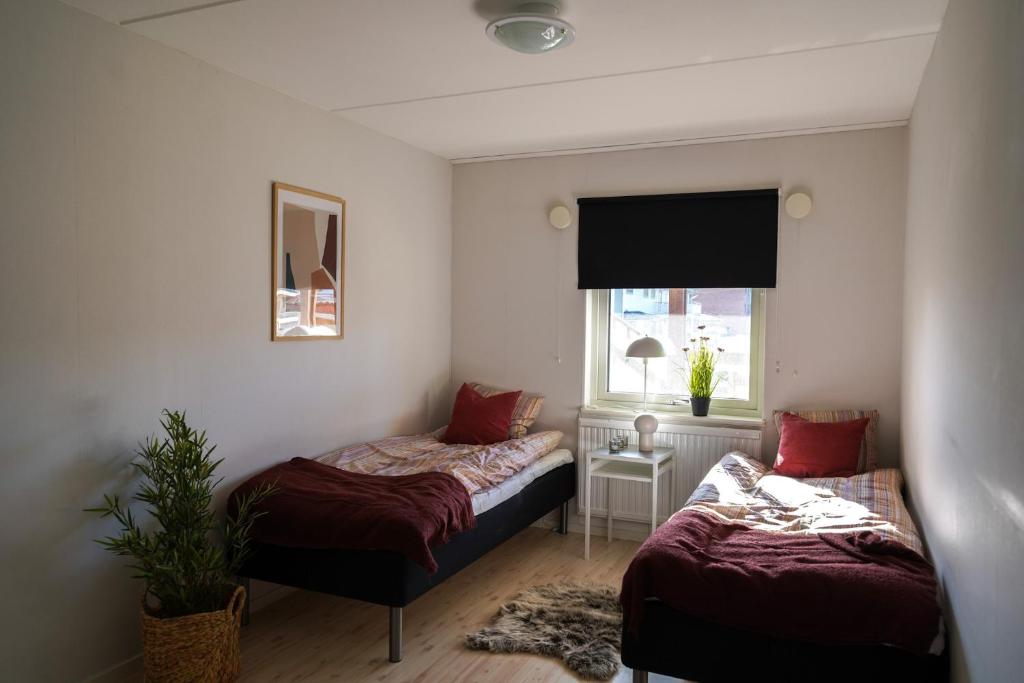 um pequeno quarto com 2 camas e uma janela em Frost Longstay Sundellsgatan 3 C em Haparanda