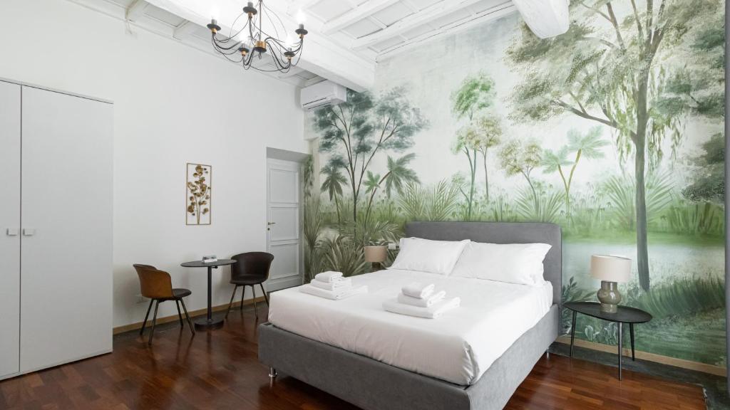 sypialnia z łóżkiem i muralem drzew w obiekcie Italianway - Barberini Elegantia Apartments Roma w Rzymie