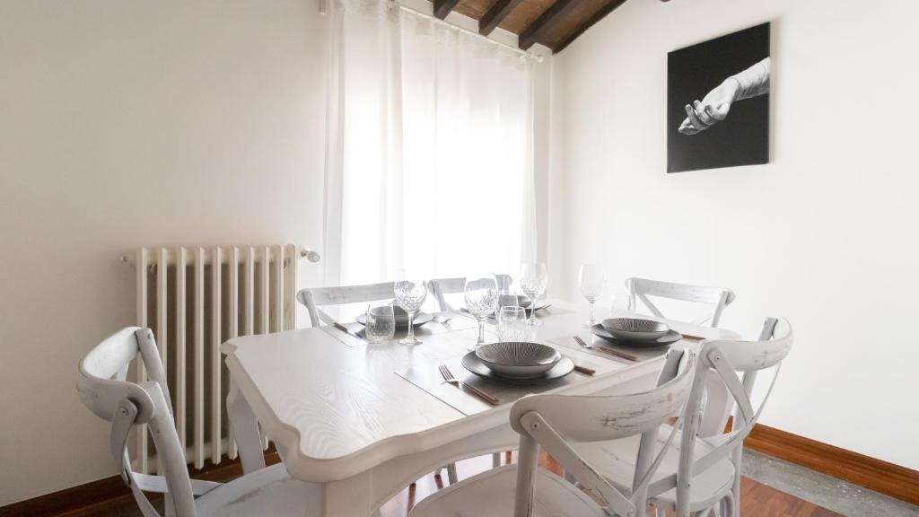 biała jadalnia z białym stołem i krzesłami w obiekcie Italianway - Barberini Elegantia Apartments Roma w Rzymie