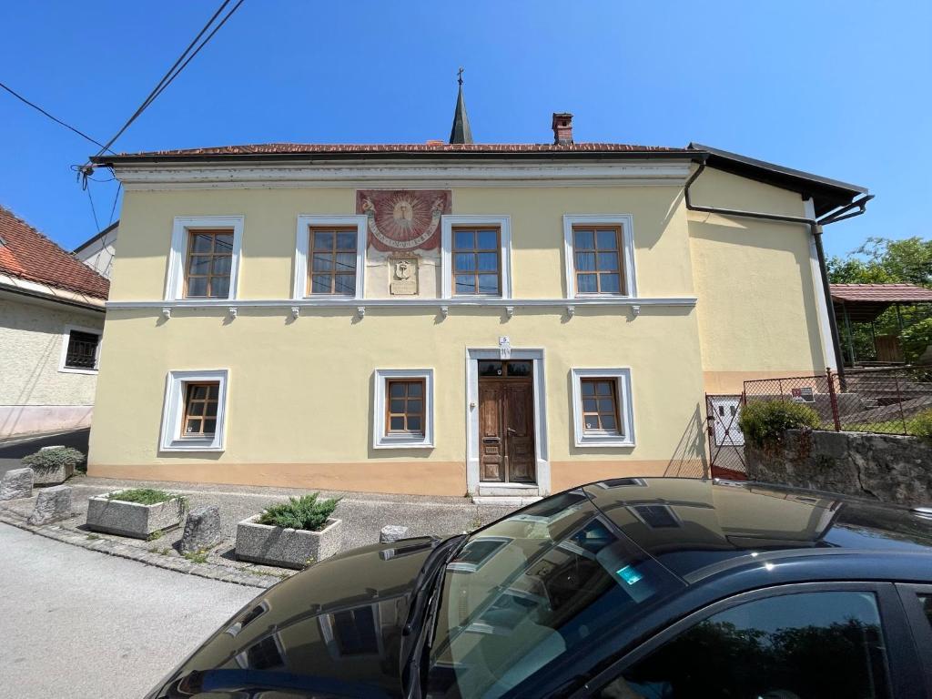 a car parked in front of a yellow house at Hiša Kapitelj in Novo Mesto