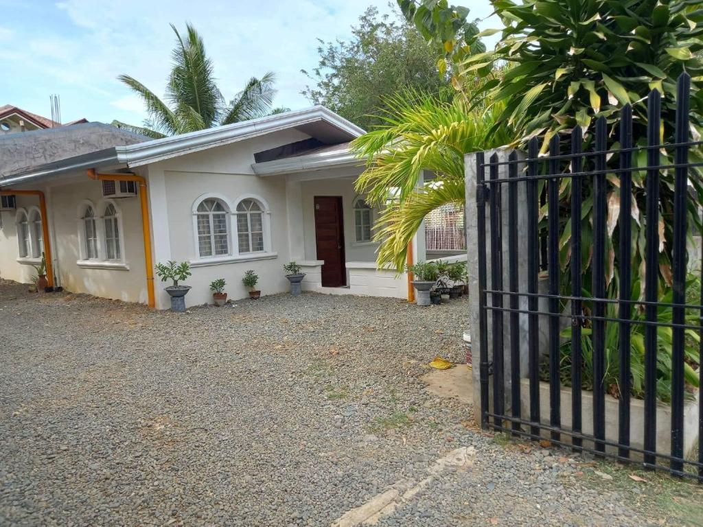 a white house with a gate in front of it at Czarina Transient House in Alaminos
