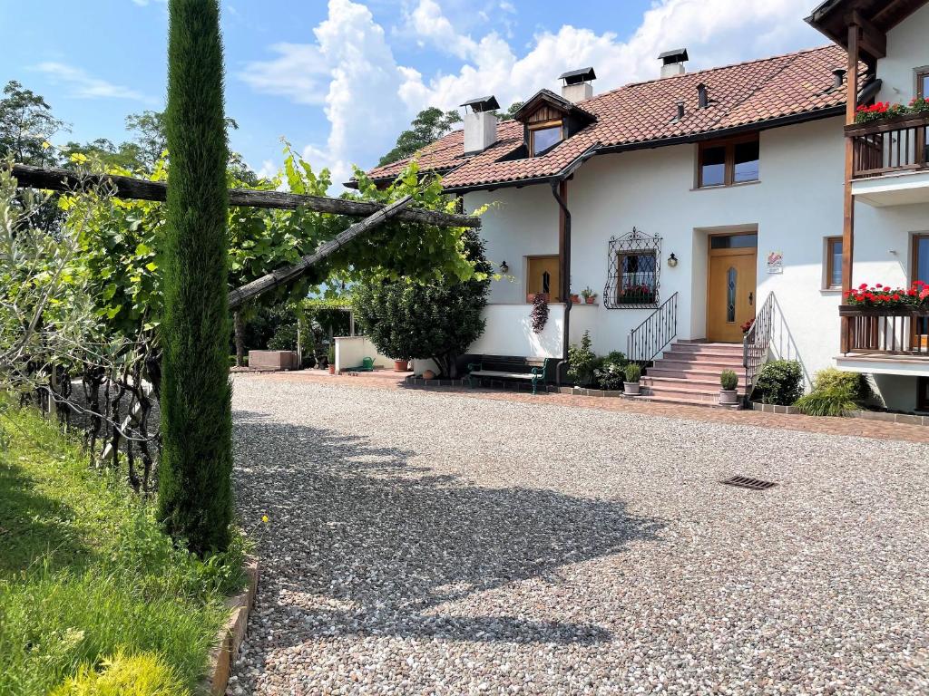 a house with a fallen tree on a driveway at Bühel im Gschleier in Appiano sulla Strada del Vino