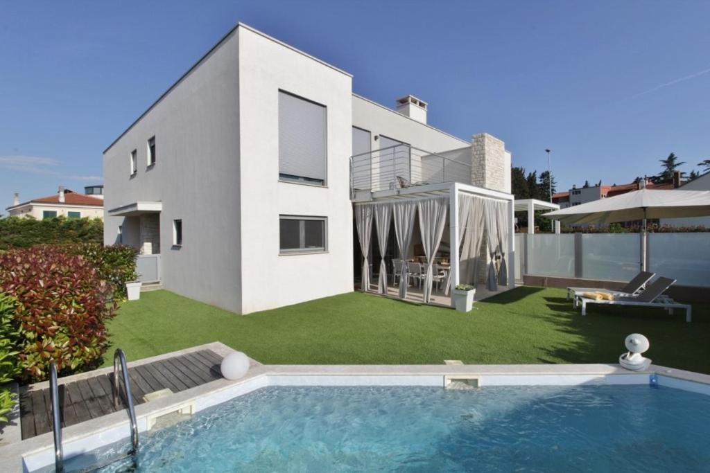 una casa con piscina frente a un patio en Villa Pura Vida with pool, en Savudrija