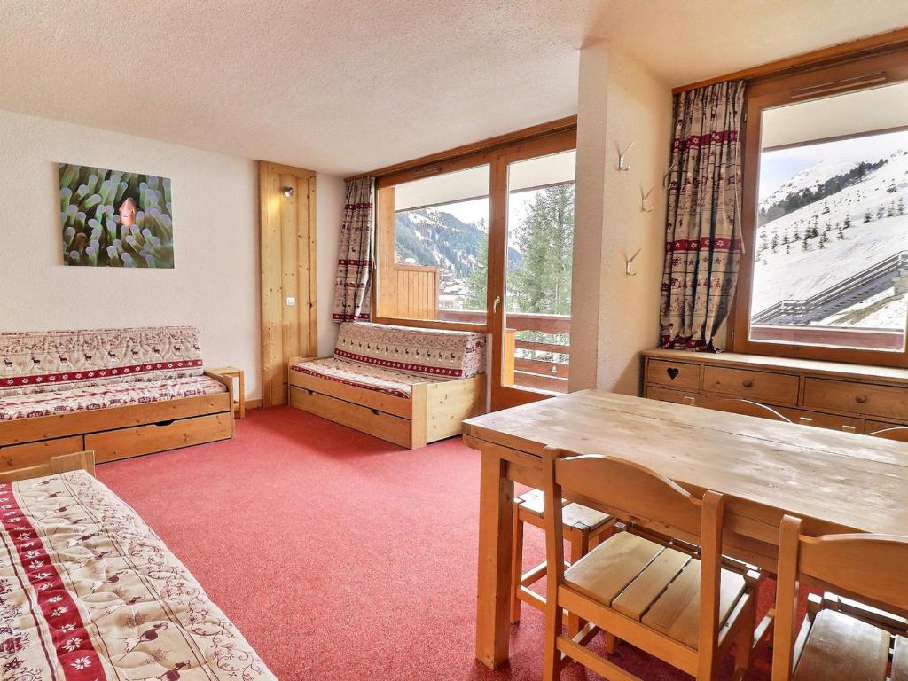 une chambre avec deux lits, une table et des chaises dans l'établissement Charmant studio lumineux skis aux pieds avec balcon et Wi-Fi - FR-1-182-8, à Méribel