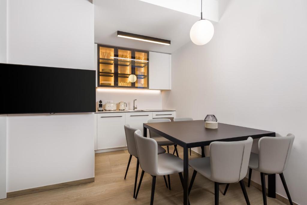 a kitchen and dining room with a black table and chairs at Studio apartments in center of Opatija in Opatija