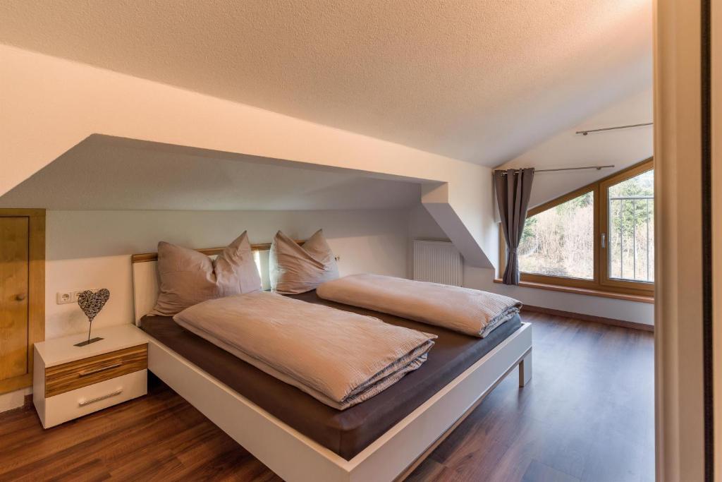 a bedroom with a large bed with a large window at Appartement Waldmoos in Ellmau