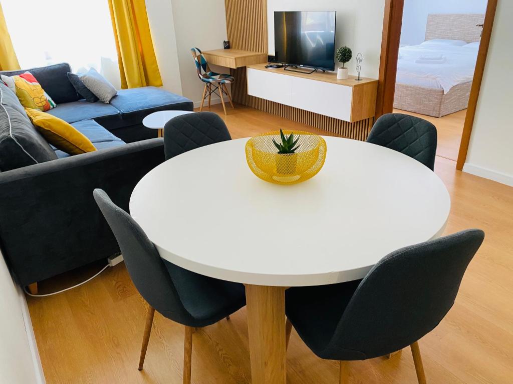 un soggiorno con tavolo e sedie bianchi di Уютен апартамент в сърцето на прекрасен град Варна a Varna
