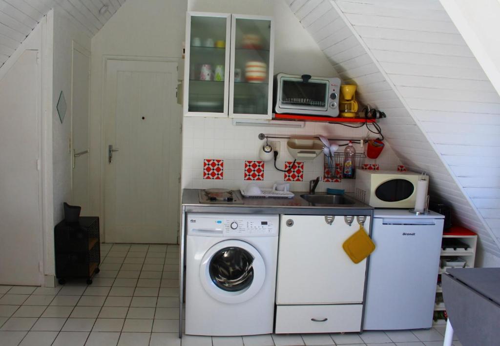 a kitchen with a washing machine and a microwave at Le studio du dolmen à Plouharnel in Plouharnel