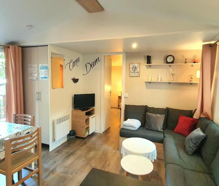 ein Wohnzimmer mit einem Sofa und einem Tisch in der Unterkunft Mer et Liberté in Saint-Brevin-les-Pins