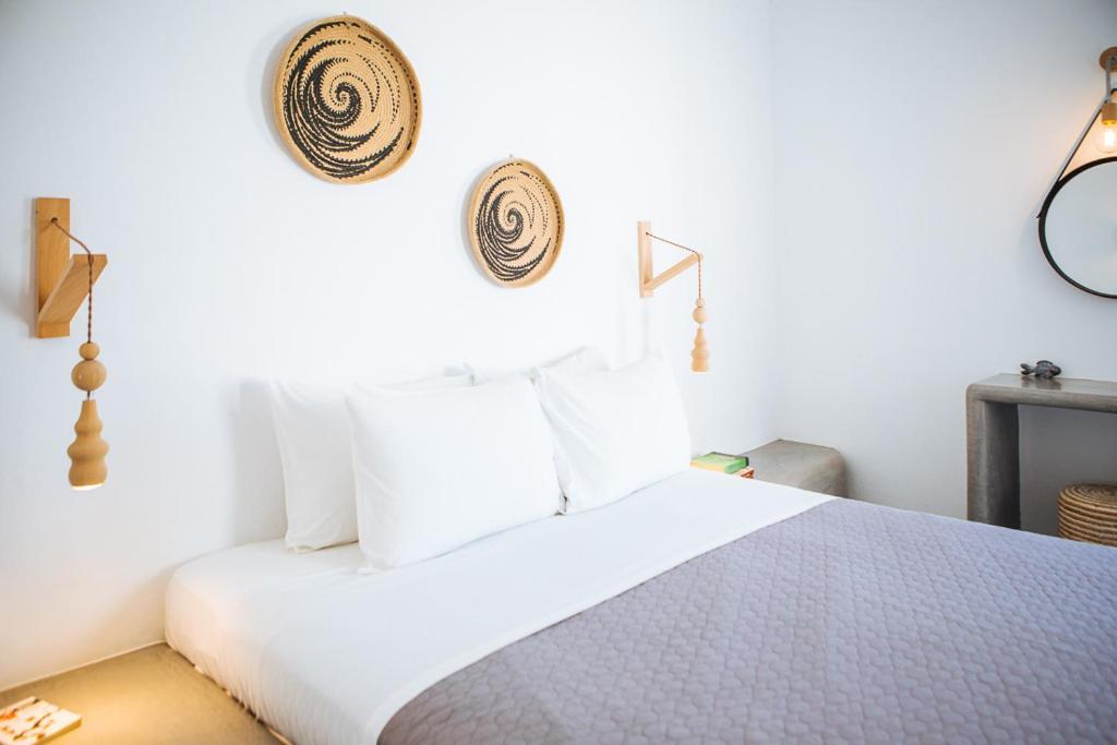 a bedroom with a white bed with white pillows at Aetheria Villas in Oia