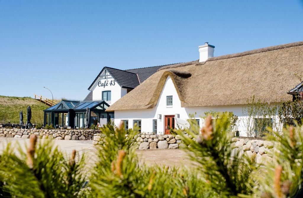 ein weißes Haus mit einem Strohdach in der Unterkunft Seaside 43 in Sankt Peter-Ording