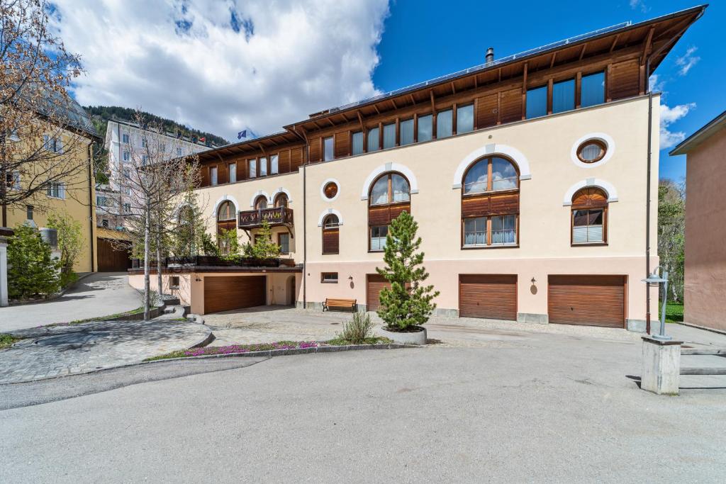 a large building with two garage doors on a street at Chesa Domiziana - Samedan in Samedan