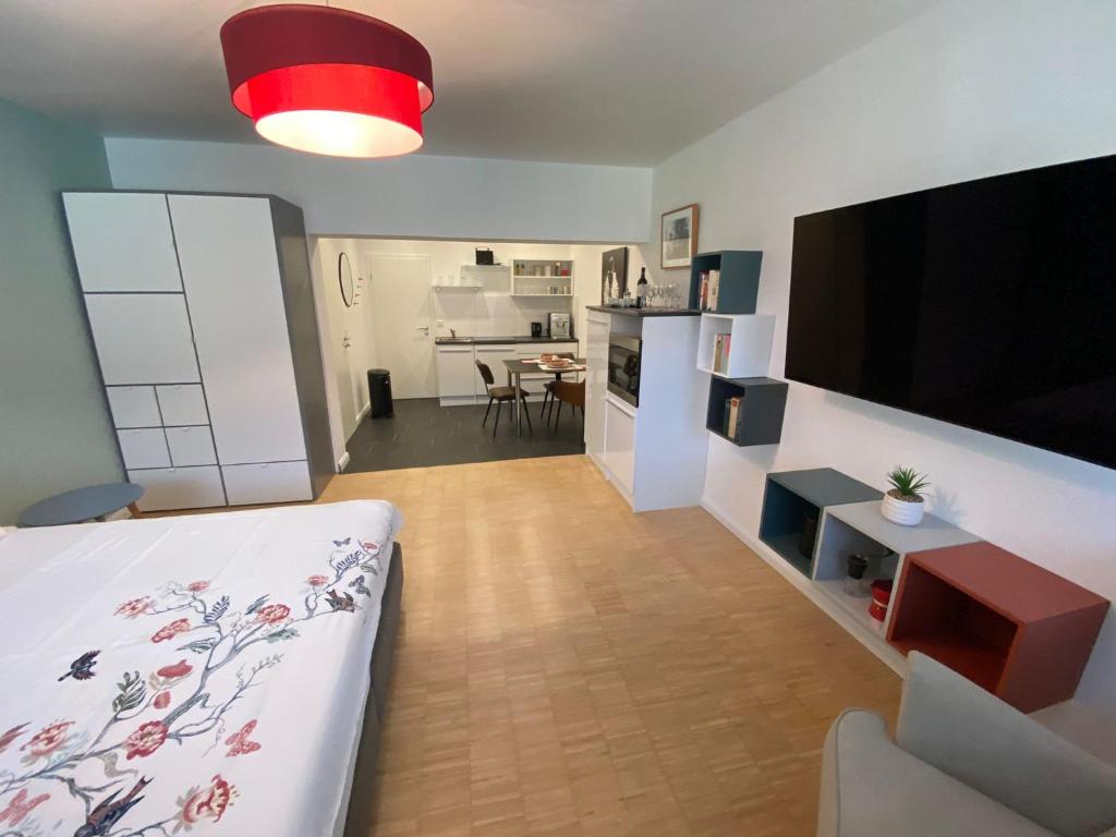 a living room with a bed and a tv and a kitchen at Tondose Apartment in Dortmund