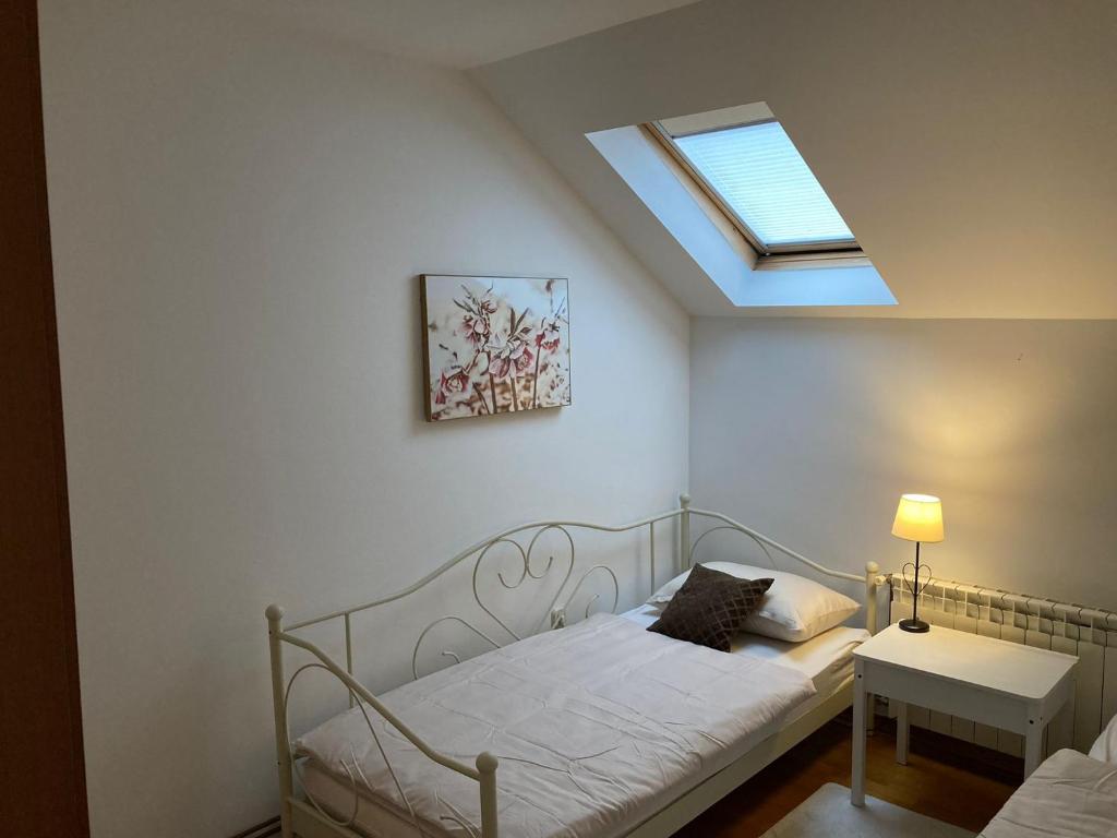 a small bedroom with a bed and a skylight at Megy in Vinkovci