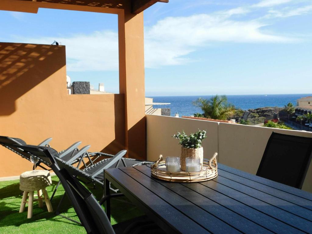 a table on a balcony with a view of the ocean at Ocean Sun & Golf II in San Miguel de Abona