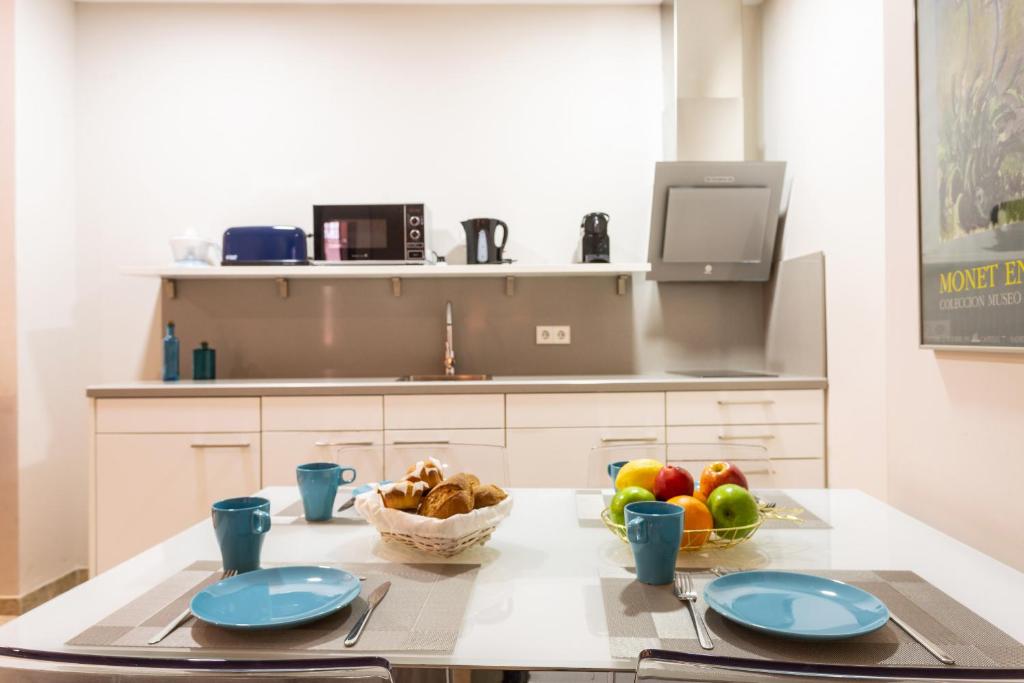 a kitchen with a table with a bowl of fruit at Green-Apartments Alto de Santa Cruz in Seville