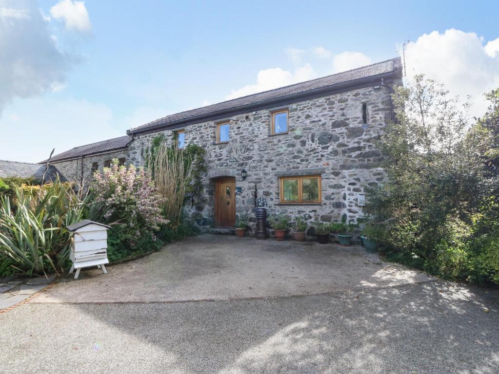 a stone house with a courtyard in front of it at Ty Gwennol in Beaumaris