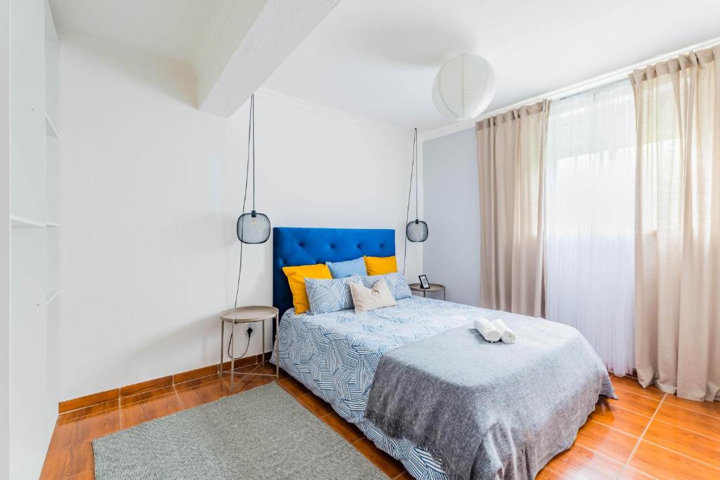 a bedroom with a bed and a blue headboard at La Maison in Anobra