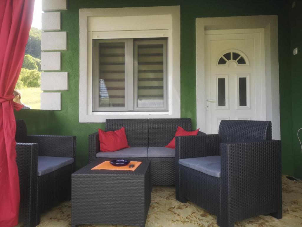 a porch with a couch and chairs and a window at Vila Jotic, Zavojsko jezero in Pirot