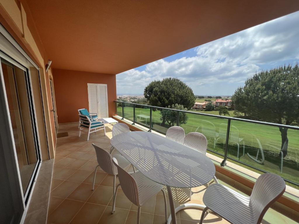 a balcony with a table and chairs and a large window at Fairway 3 Appartement - Boavista Golf & Spa Resort in Lagos