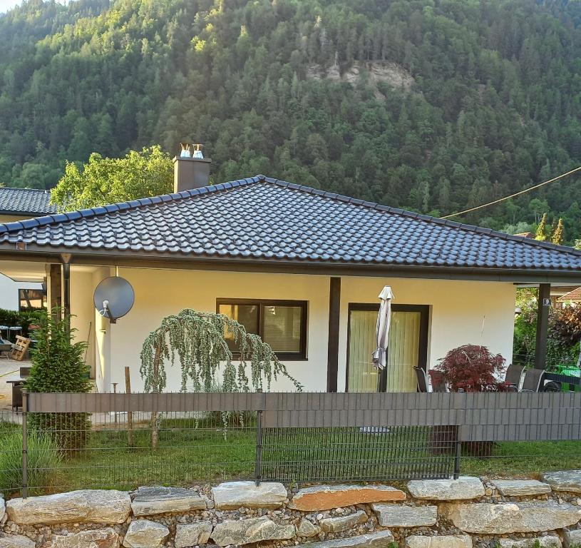 ein kleines Haus mit einem Berg im Hintergrund in der Unterkunft Ferienhaus Natura 2000 in Steindorf am Ossiacher See