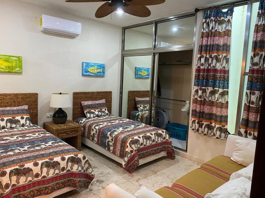 1 dormitorio con 2 camas y espejo en Waterfront 3 Bedroom Spacious Condo, en Playa del Carmen