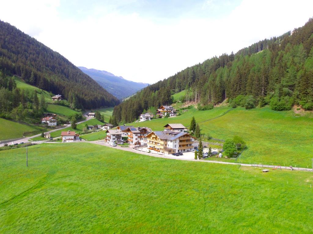 an aerial view of a house in a green field at Almhotel Bergerhof in Sarntal