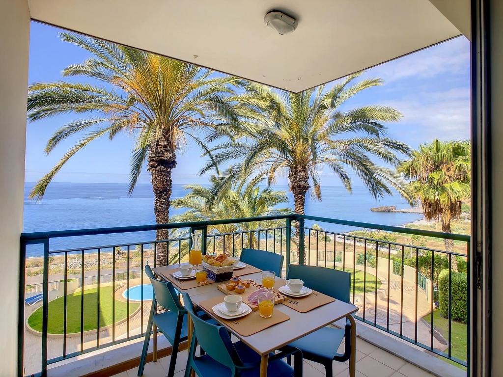 a table with chairs on a balcony with a view of the ocean at Vila Formosa Top View by LovelyStay in Funchal