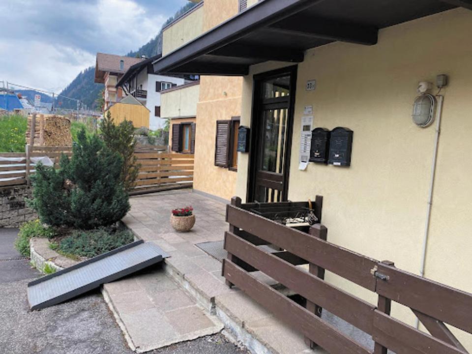 una casa con una valla de madera junto a una puerta en Minghetti en Predazzo