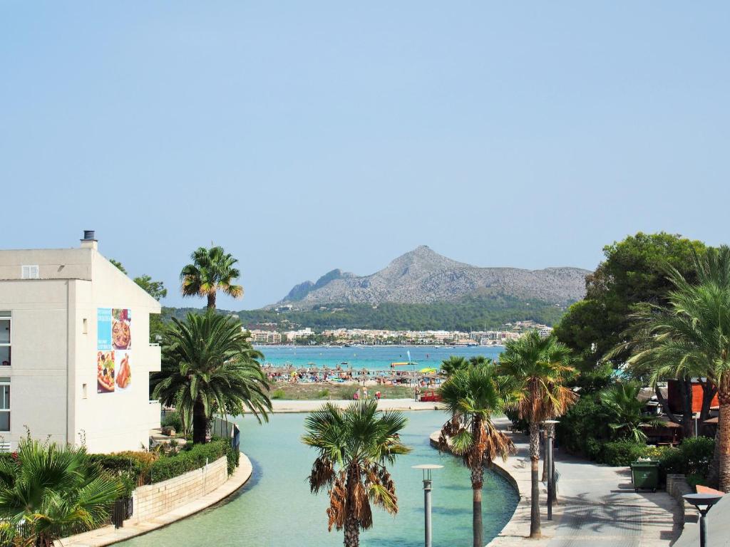 a view of a river with palm trees and a beach at Venecia Apartments in Port d'Alcudia