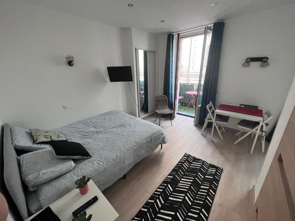 une chambre avec un lit, un bureau et une fenêtre dans l'établissement Appartement Cosy centre ville Aix les bains (Cures et courts sejours), à Aix-les-Bains