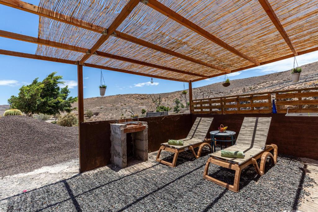 a patio with two chairs and a table and a grill at La Fortaleza - Casa La Fuentita in El Charco