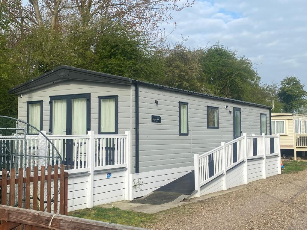 a gray and white trailer with a white fence at Starling Six Berth caravan in Alford