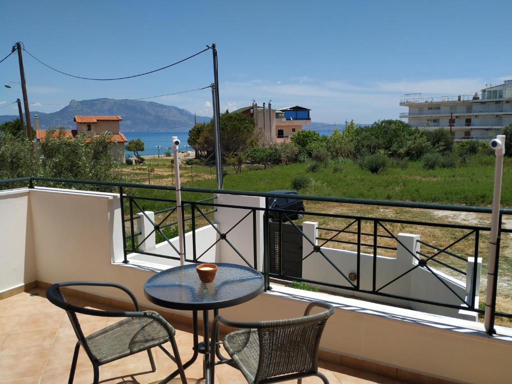 a balcony with a table and chairs and a view of the ocean at Villa on the Beach in Periyiálion