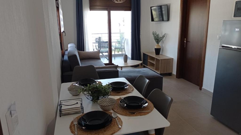 a kitchen and living room with a table and chairs at Melograno Apartment in Ammouliani