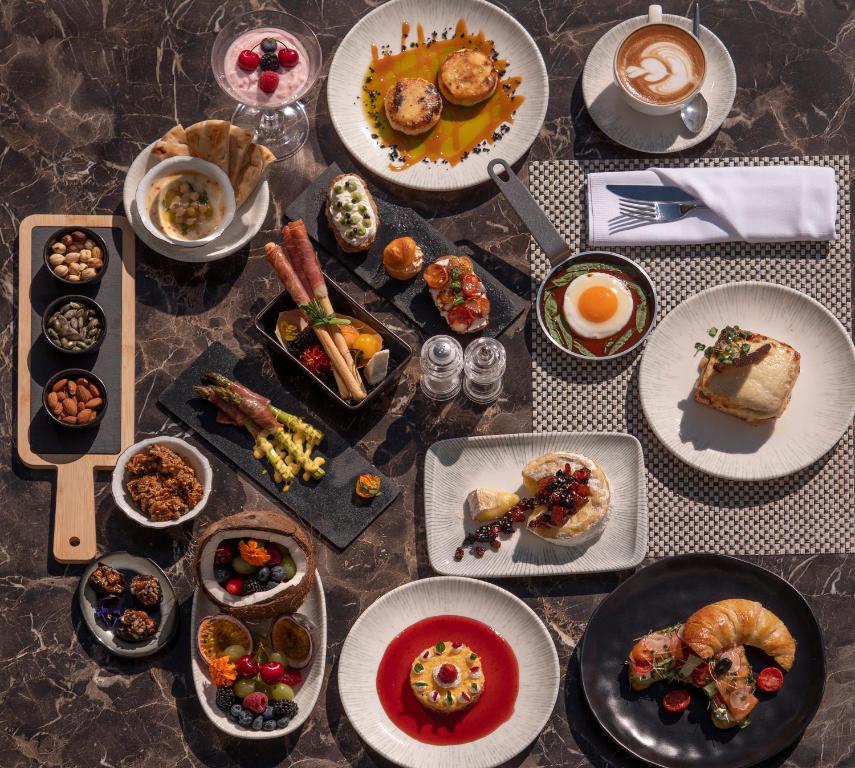 a table with many plates of food on it at Vivid Blue Serenity Resort in Sveti Stefan