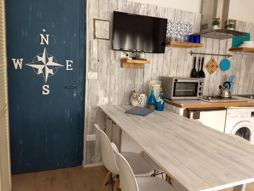 eine Küche mit einem Holztisch und Stühlen in der Unterkunft "Beach Cottage" monolocale vicino alla spiaggia in Chioggia