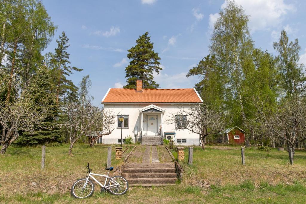 a bike parked in front of a white house at Cozy Home in Ydrefors in Ydrefors