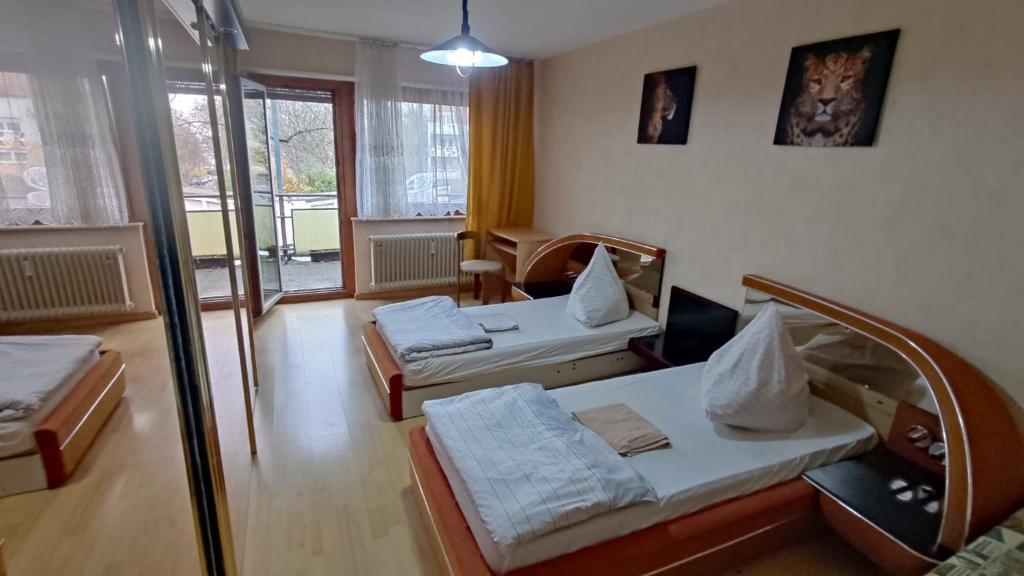- un salon avec 2 lits et une porte en verre dans l'établissement Kämen 2 Zimmer, à Stuttgart