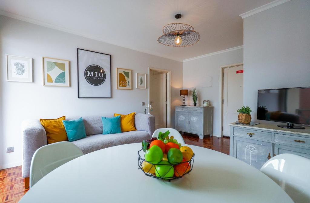 ein Wohnzimmer mit einem Tisch und einer Obstschale darauf in der Unterkunft MIO Apartment by Madeira Sun Travel in Funchal
